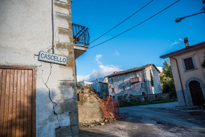 Street amidst buildings against blue sky