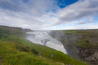 Scenic view of waterfall against sky