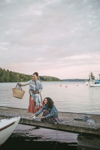 People sitting on boat in sea against sky