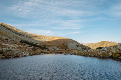 Scenic view of lake by mountains against sky