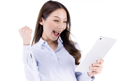 Young woman using mobile phone against white background