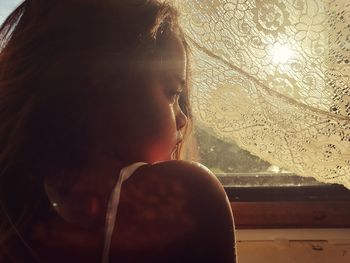 Portrait of girl looking through window