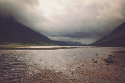 Scenic view of mountains against cloudy sky