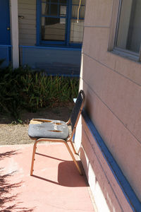 Empty bench in yard during sunny day