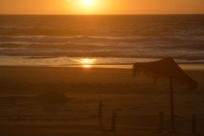 Scenic view of beach against sky during sunset