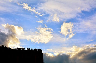 Low angle view of silhouette buildings against sky