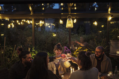 Friends having meal in greenhouse