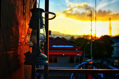Close-up of illuminated electric lamp against sky at sunset