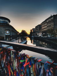 Panoramic view of boats moored at river in city against sky