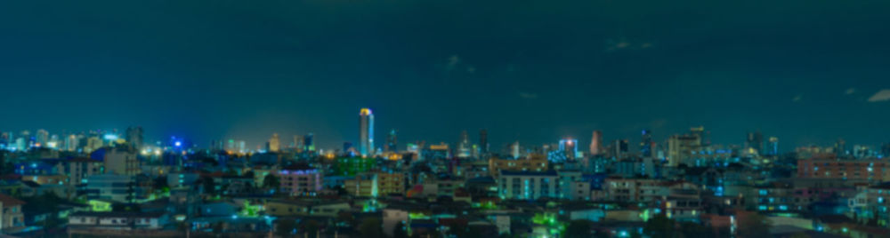 Panoramic view of illuminated buildings against sky at night