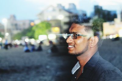 Side view of young man seen through window with reflection