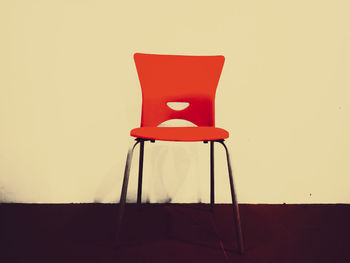 Red chair on table against wall at home