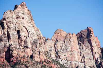 Low angle view of rocky mountains against clear sky