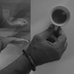 Midsection of man holding coffee cup