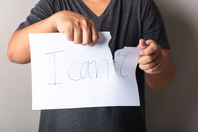 Midsection of woman holding paper with text