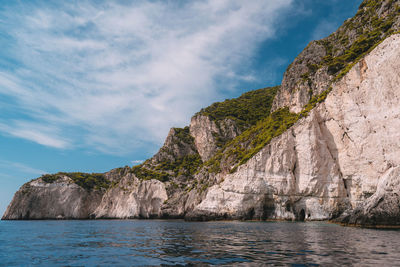 Rock formations by sea against sky