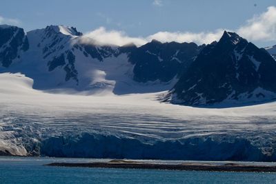 Arctic glacier descends its valley to melt into the arctic ocean