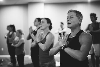 Women doing yoga while standing at studio