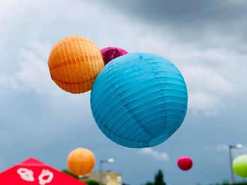 Low angle view of lanterns hanging against sky