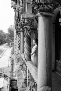 Side view of woman standing by building