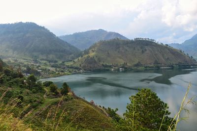Scenic view of river and mountains against sky
