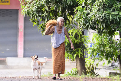 Woman with dog standing by plants