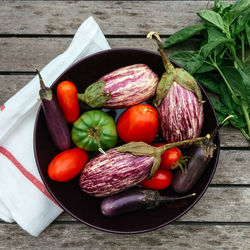 Directly above shot of tomatoes with eggplants and chili peppers in bowl