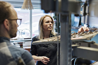 Couple working at eyeglasses workshop