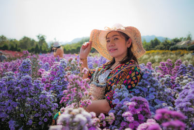 Full length of woman with pink flowers on field