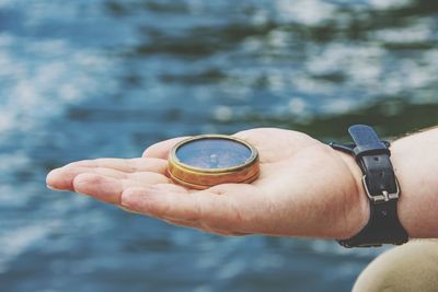 Cropped hand holding navigational compass