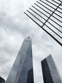 Low angle view of modern building against cloudy sky