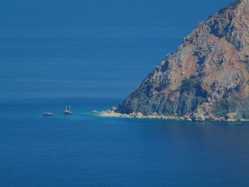 Sailboats sailing in sea against blue sky