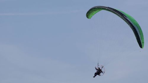 Low angle view of person paragliding against clear sky