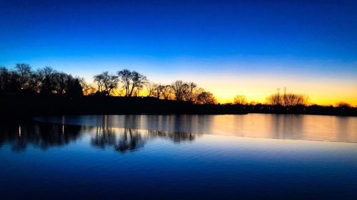 Scenic view of lake against sky at sunset
