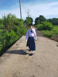 Rear view of woman walking on road