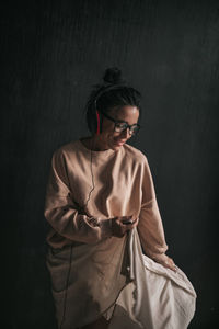 Young woman standing against black background