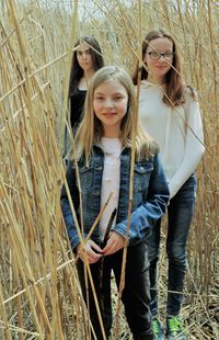 Portrait of girls standing amidst plants