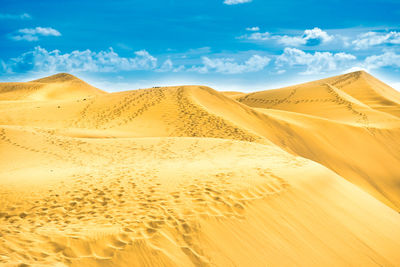 Sand dunes in desert against sky