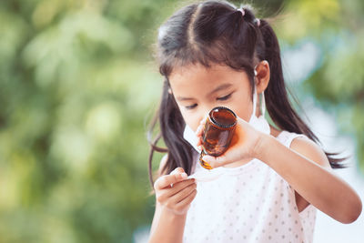 Close-up of girl taking syrup in spoon