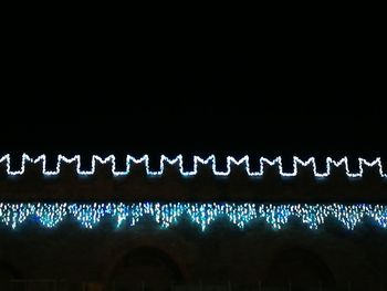 Illuminated text against clear sky at night