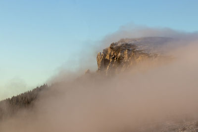 Scenic view of land against sky during foggy weather