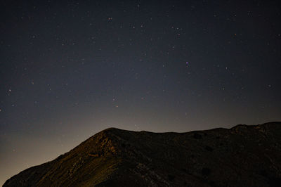 Low angle view of mountain against sky at night