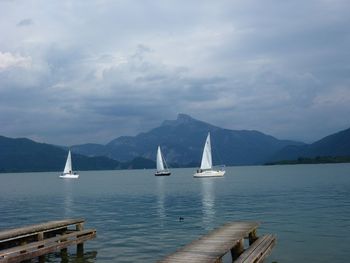 Boats in sea with mountains in background