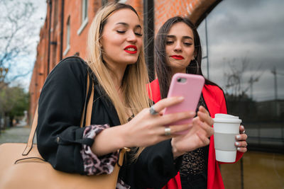 Young woman photographing with mobile phone