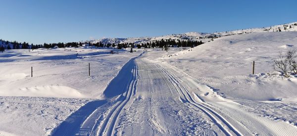 Snow covered landscape against clear sky