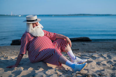 Woman sitting on shore at beach