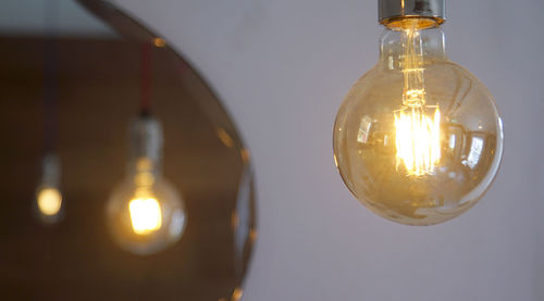 Close-up of illuminated light bulb on table