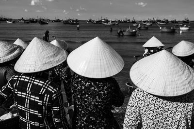 Group of people at beach against sky