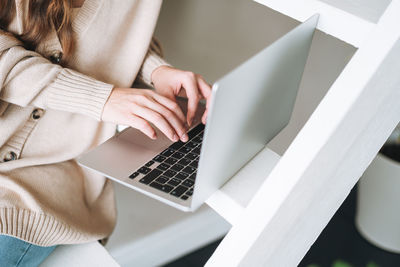 Midsection of woman using laptop