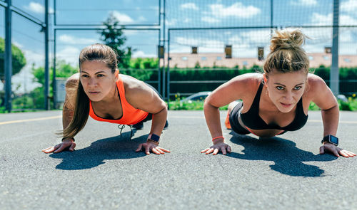 Women doing push-ups on road